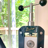 Close-up of printmaking press with 'Shirley' branding  in an indoor setting.