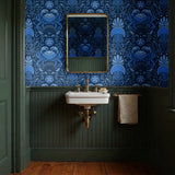Symmetrical blue folk art design with hands forming heart shape, surrounded by botanical motifs