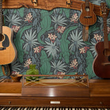 Tropical pattern with green alligators, palm fronds, and coral flowers on dark background