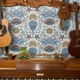 Symmetrical coastal pattern with crab, starfish, seashells, and seaweed in blue, brown, and pink ton
