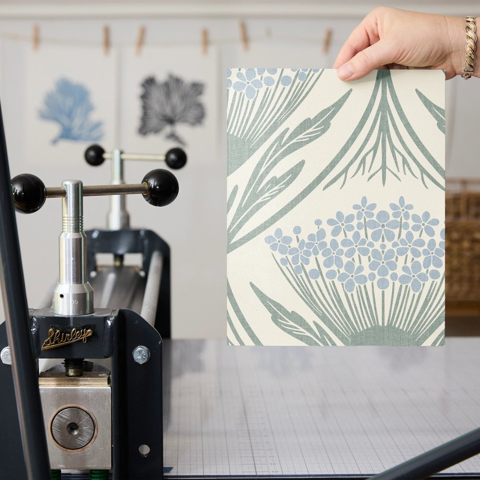 Art Nouveau floral pattern with stylized blue flowers and sage green leaves on cream background
