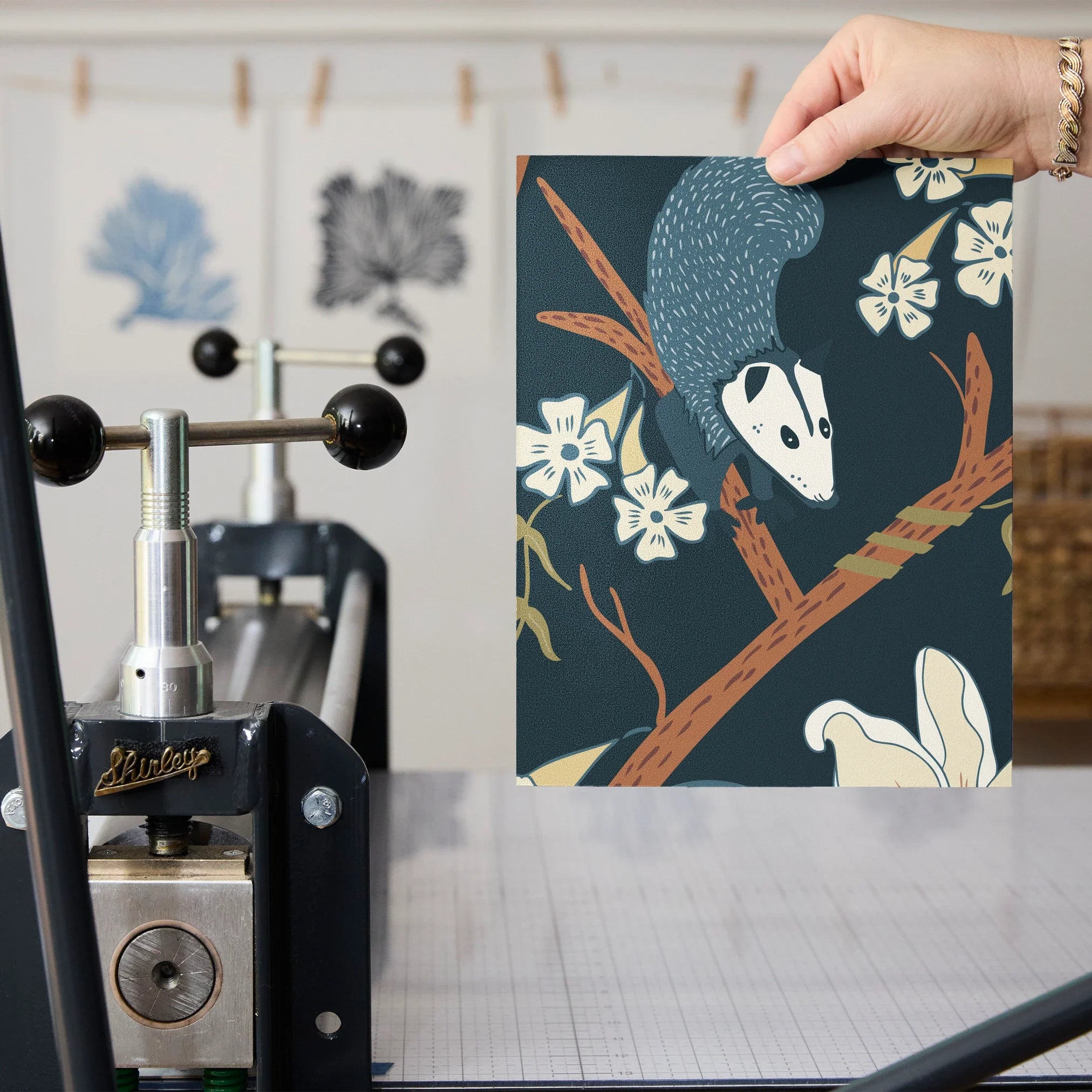 Dark floral pattern with cream magnolias, blue berries, green leaves and brown branches on black bac
