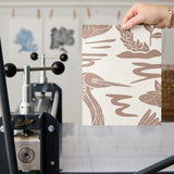 Tropical pattern with brown birds, palm fronds, and foliage on cream background