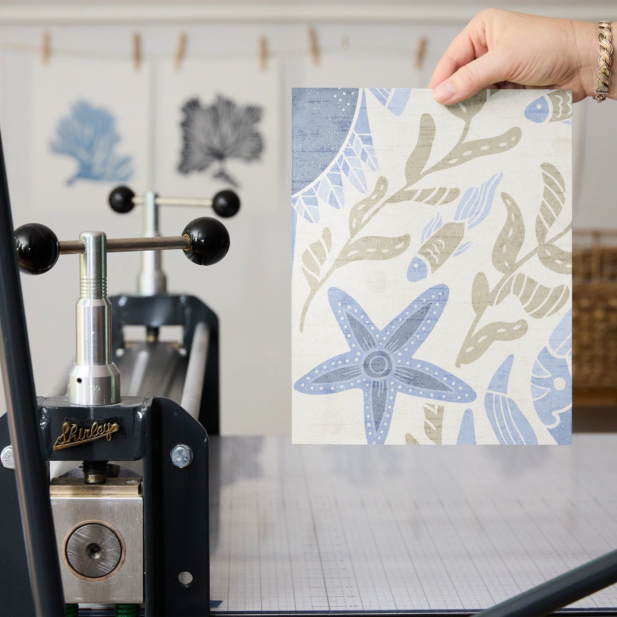 Symmetrical coastal damask pattern with crabs, starfish, shells, and seaweed in blue and tan