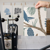 Birds and pine cones on branches in blue, green, and beige decorative pattern