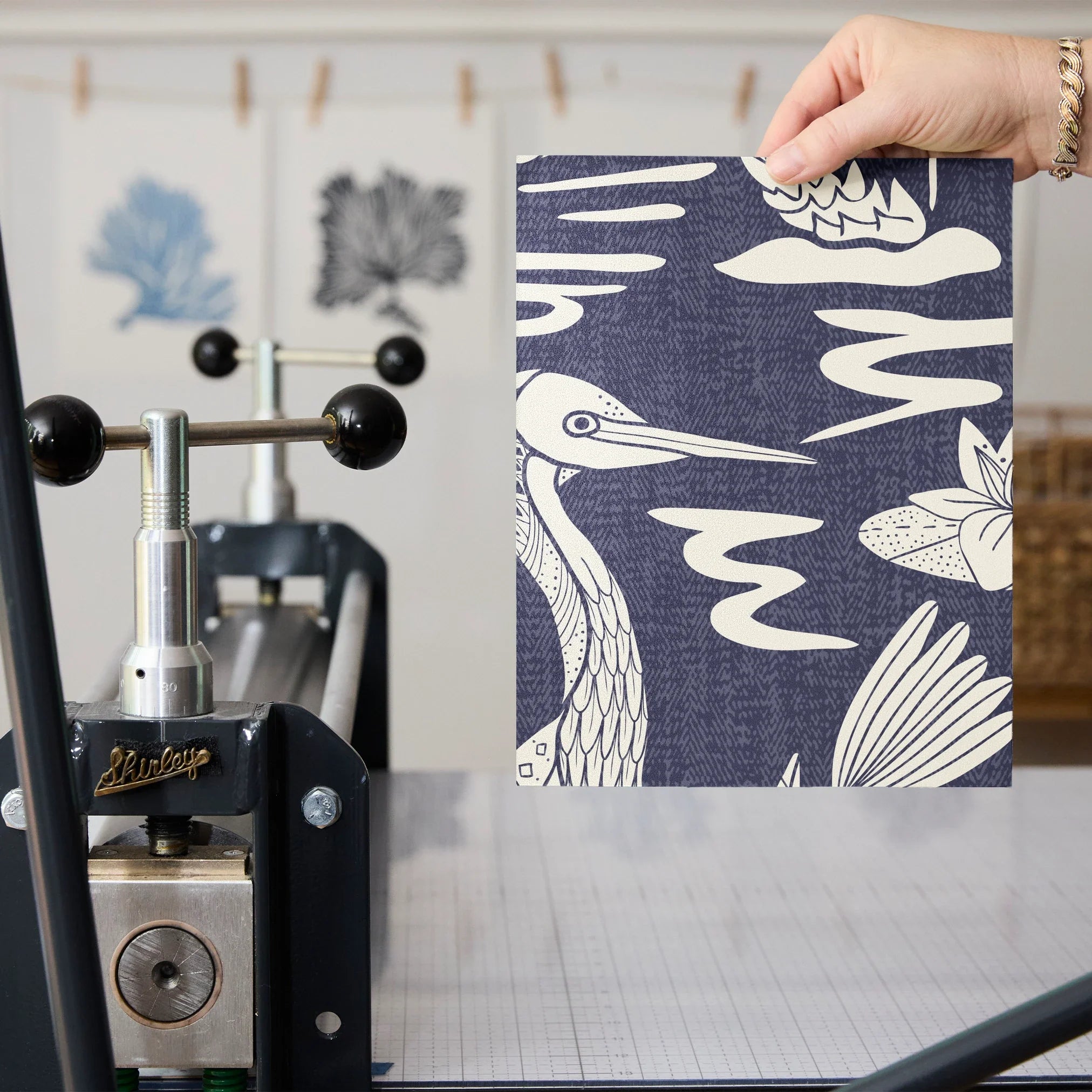 Navy blue background with white tropical birds, palm fronds, and botanical motifs in repeating patte