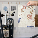 Decorative pattern with blue birds, rust-colored flowers, and brown foliage on cream background