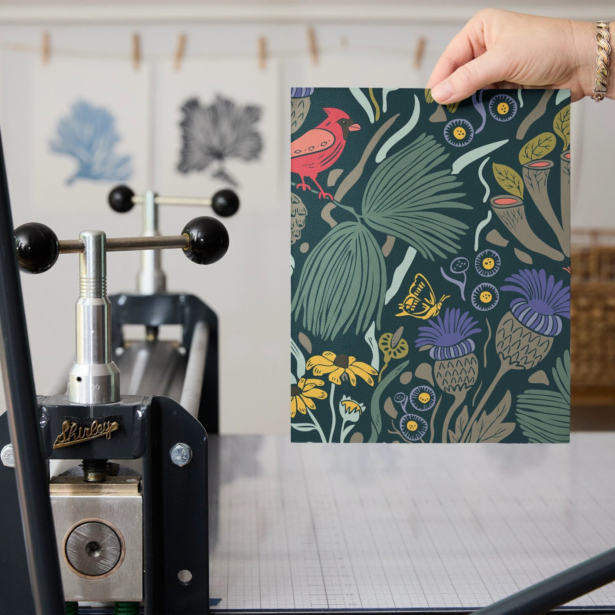Dense floral pattern with red birds, tropical leaves, flowers and berries on dark teal background