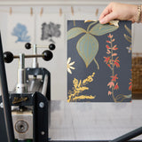 Vintage floral pattern with white flowers, golden stalks, and red blooms on dark gray background
