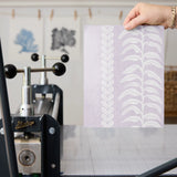 White feather and chevron pattern stripes on soft purple background