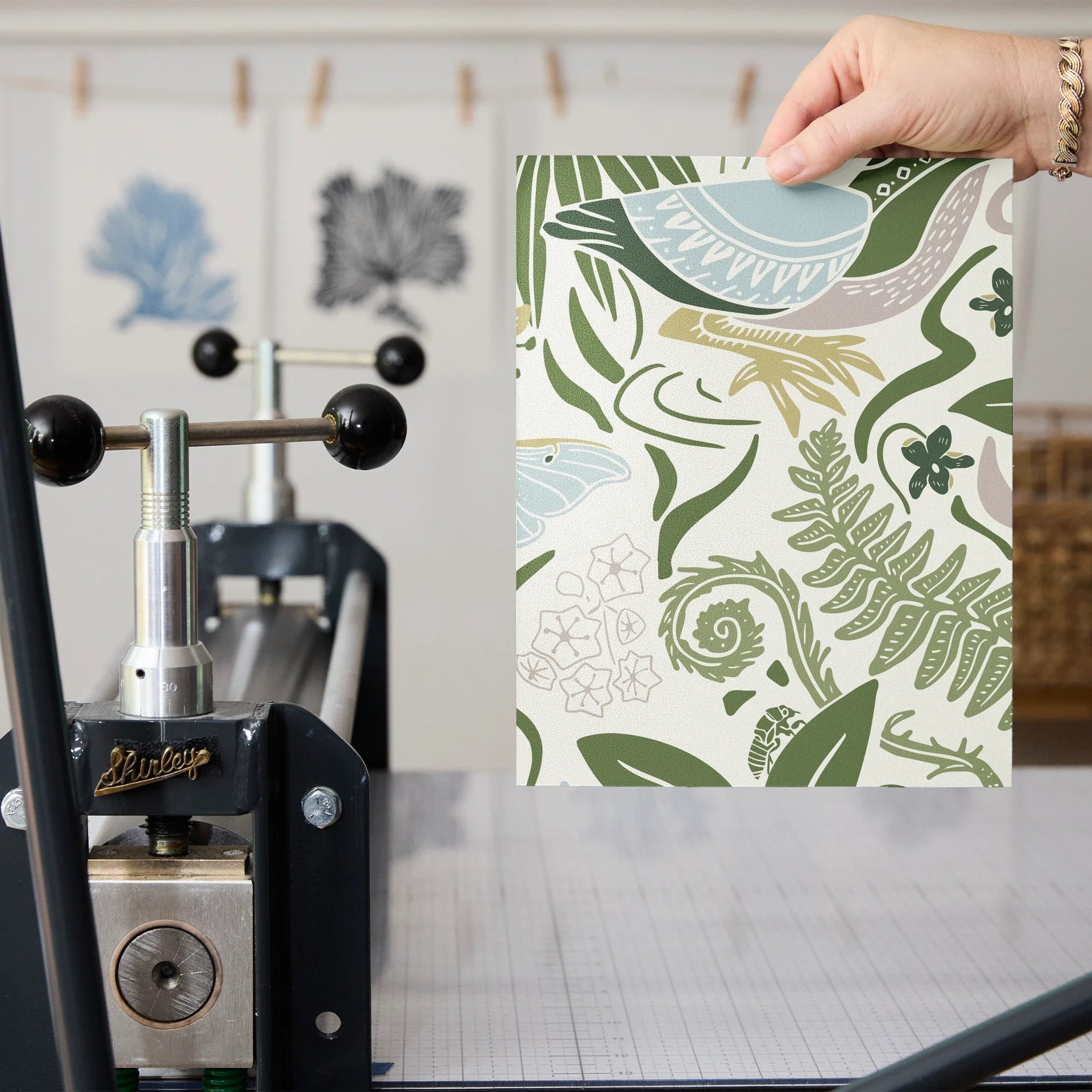 Decorative botanical pattern with green ferns, leaves, mushrooms, and flowers on cream background