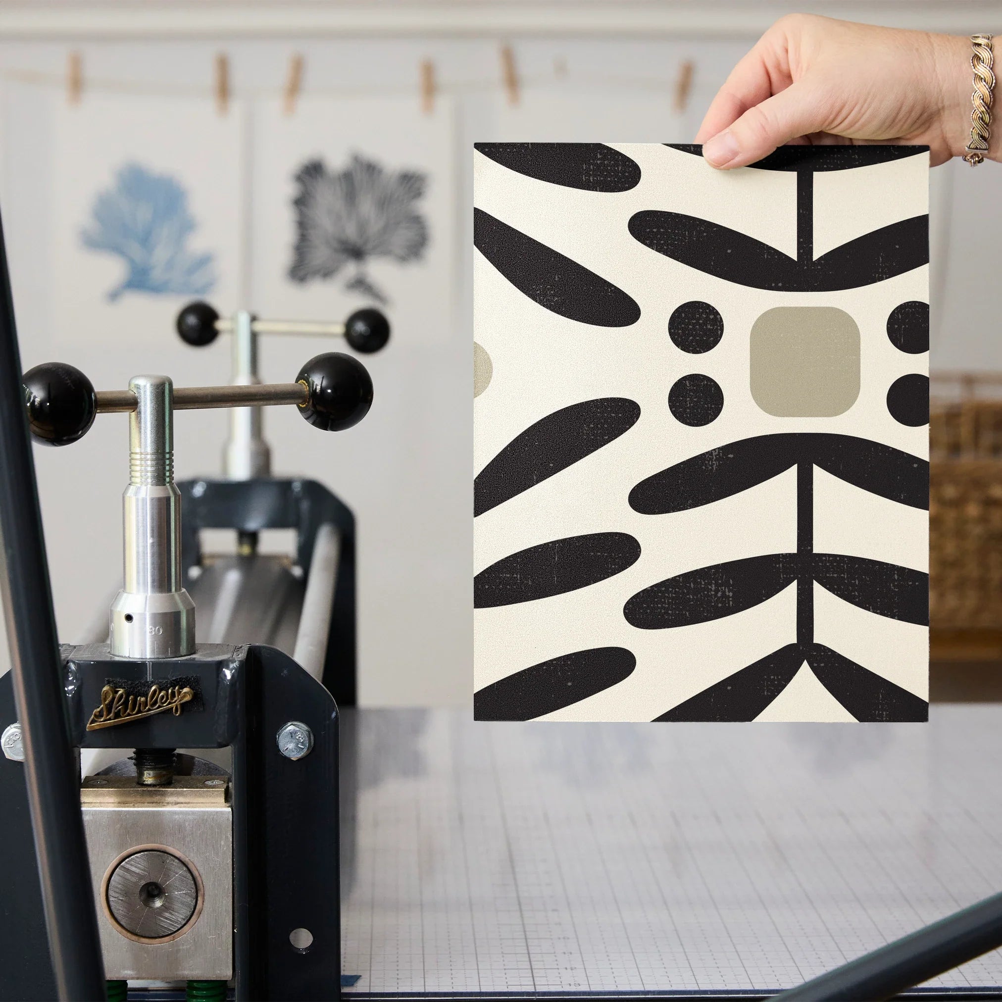 Geometric pattern with black botanical motifs and tan circles on cream background