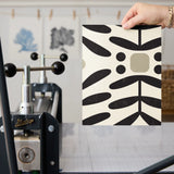 Geometric pattern with black botanical motifs and tan circles on cream background