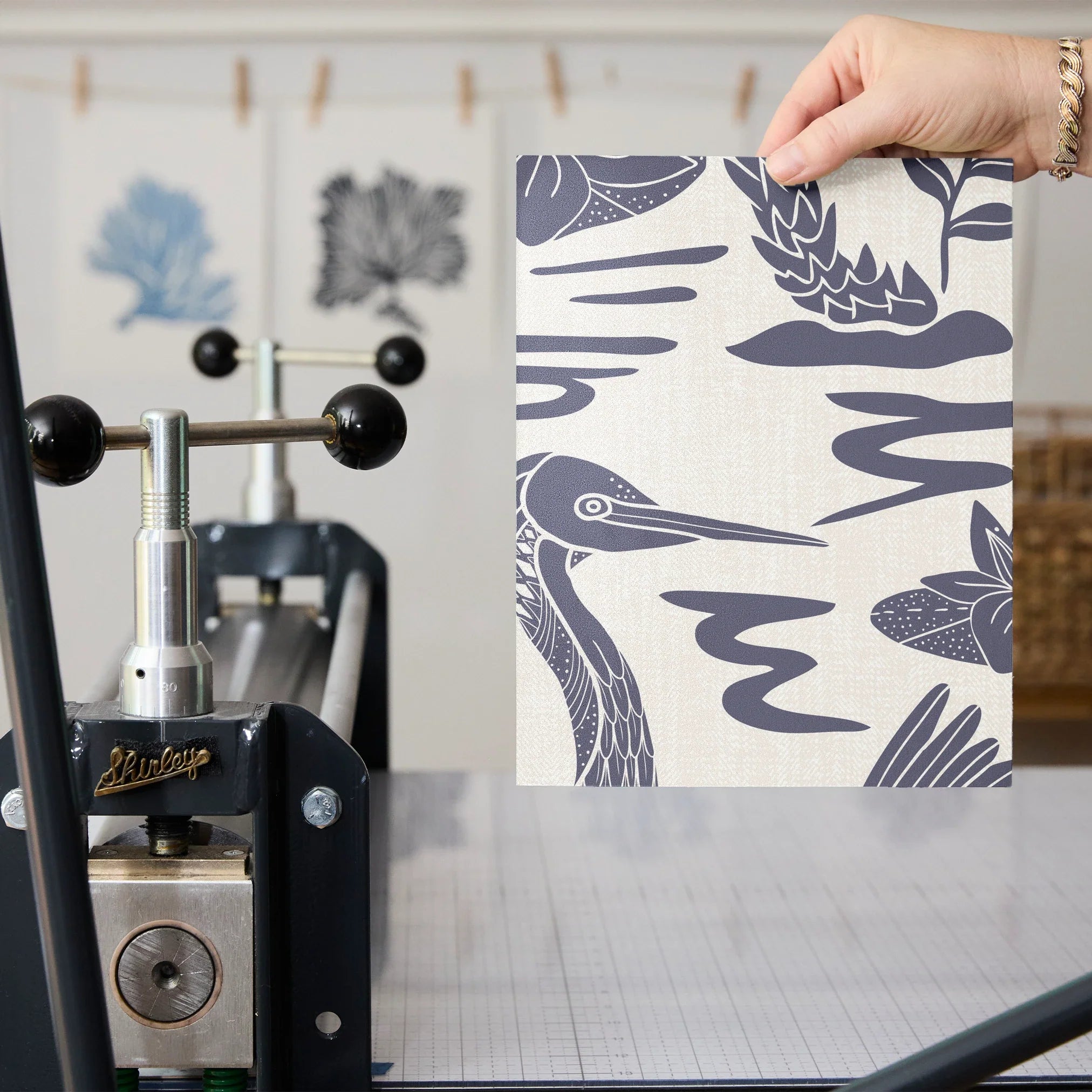 Tropical botanical pattern with blue herons, palm fronds, and foliage on cream background