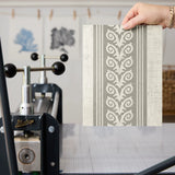 Vertical stripes pattern in beige and white with decorative scrollwork motifs alternating with plain