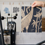 Herons and cranes among reeds and flowers in beige on dark navy blue background