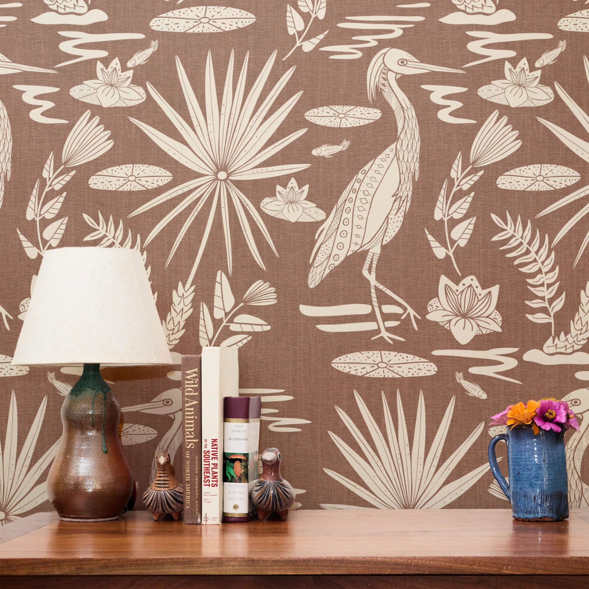 Tropical bird and palm leaf pattern in cream on terracotta brown background