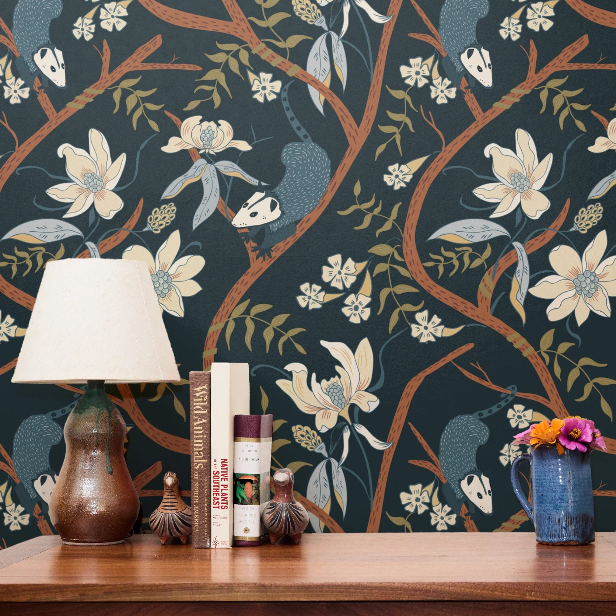 Dark floral pattern with cream magnolias, blue berries, green leaves and brown branches on black bac