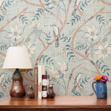 Delicate floral pattern with white flowers, blue-gray leaves, and coral branches on pale blue backgr