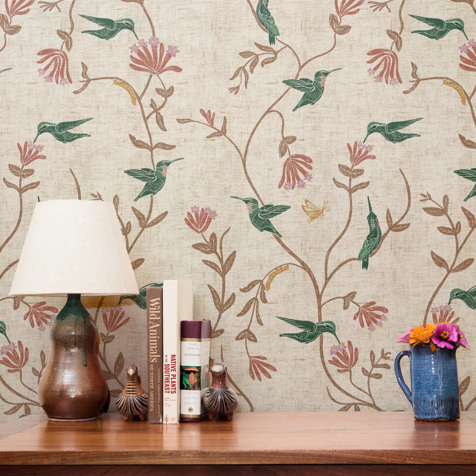 Floral pattern with hummingbirds, pink flowers, and tan foliage on cream textured background