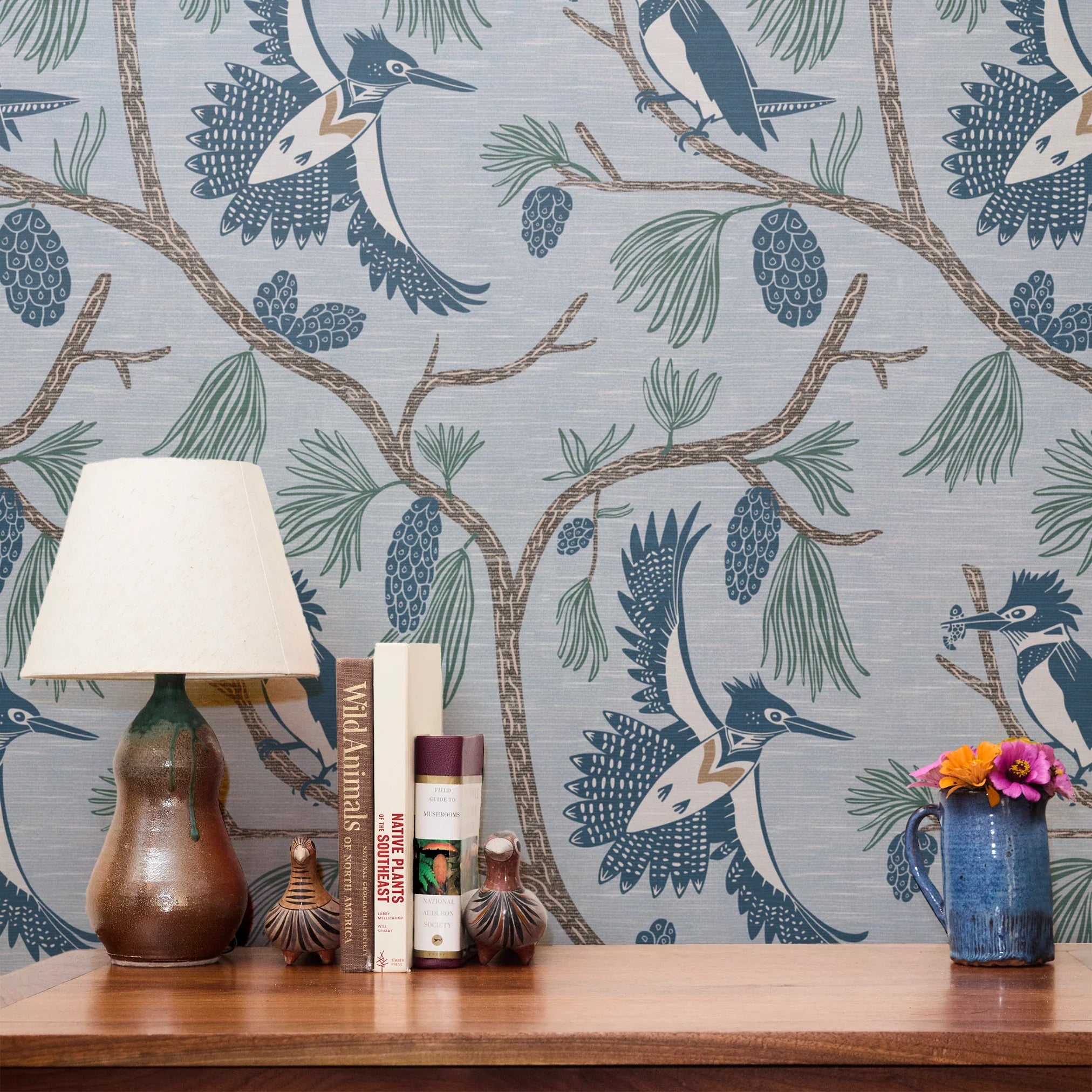 Birds perched on branches with pine cones and needles in blue, brown, and cream tones