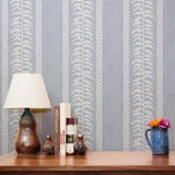 Blue and white vertical stripe pattern with leaf motifs and textured linen background