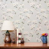 Delicate floral pattern with gray-green leaves and white flowers on light gray background