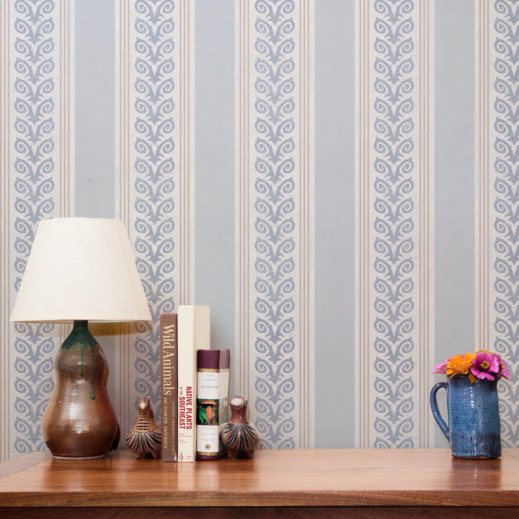Blue and white vertical striped pattern with decorative floral motifs