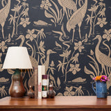 Herons and cranes among reeds and flowers in beige on dark navy blue background