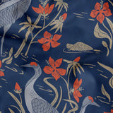 Blue wallpaper pattern with white herons, coral flowers, and green foliage in an Art Nouveau style