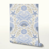 Symmetrical coastal damask pattern with crabs, starfish, shells, and seaweed in blue and tan
