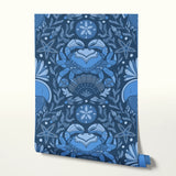 Symmetrical blue folk art design with hands forming heart shape, surrounded by botanical motifs
