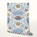 Symmetrical coastal pattern with crab, starfish, seashells, and seaweed in blue, brown, and pink ton