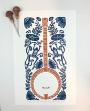 Load image into Gallery viewer, Banjo and Frog,  Hand pulled block print in copper and navy with 13x19 mat
